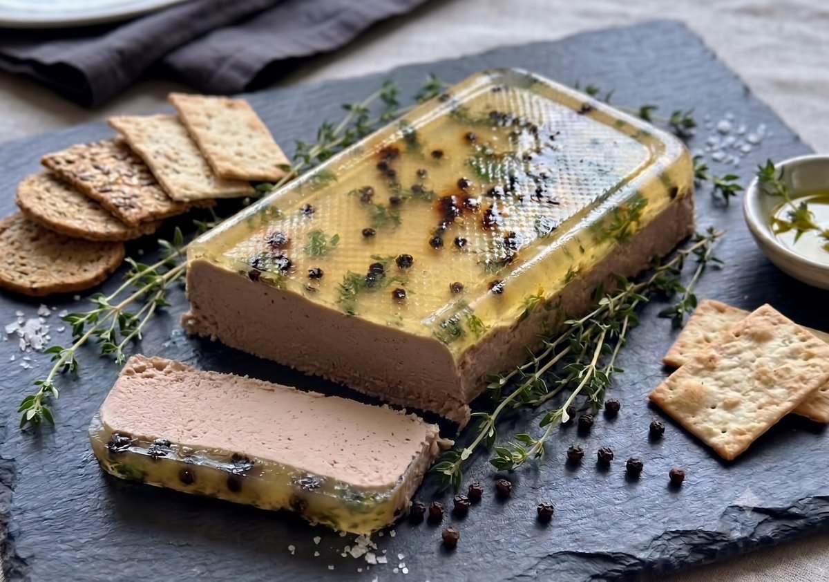 Hand-crafted chicken liver pâté terrine set with peppercorns and thyme, served with crackers on slate